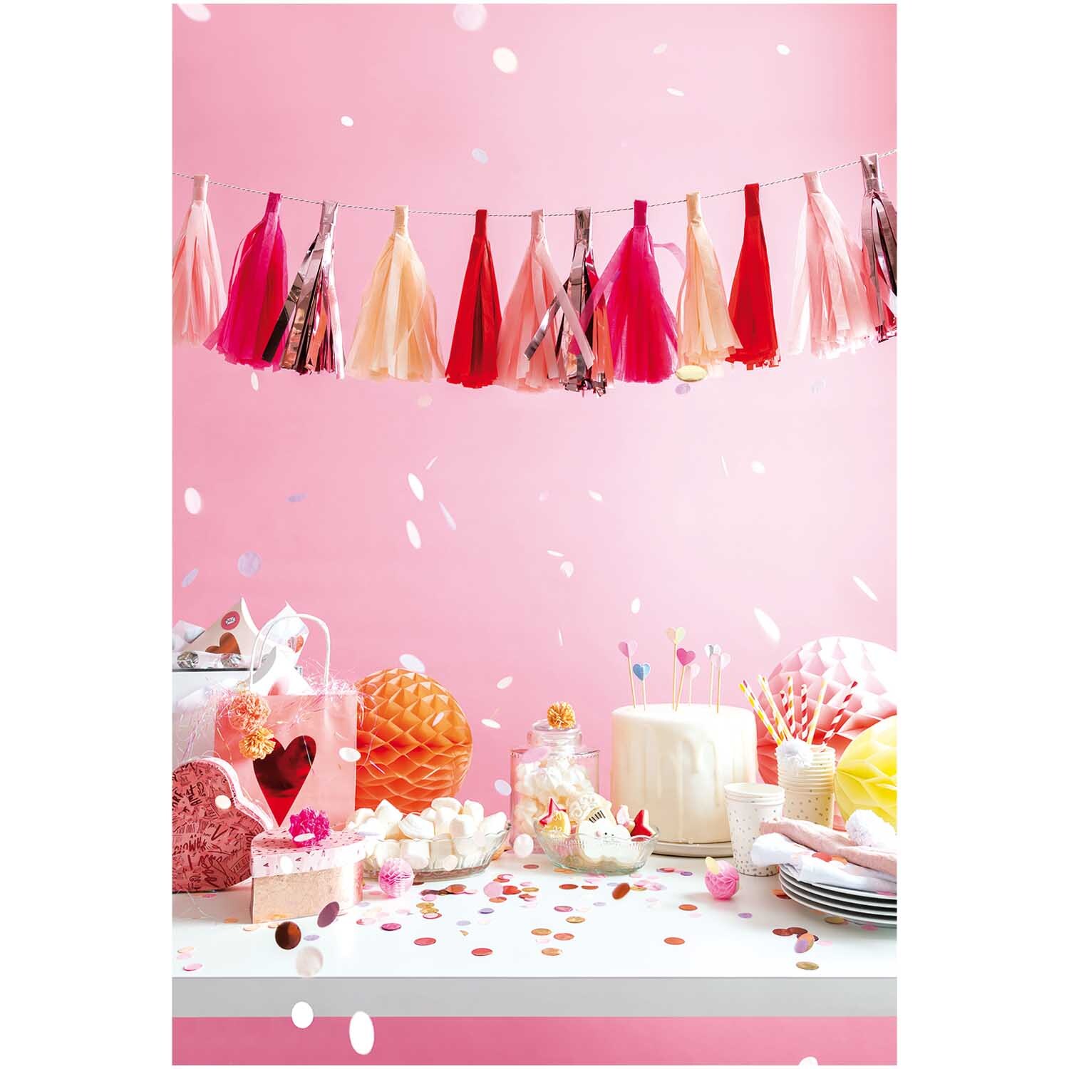 Quasten-Girlande 2m 12 Quasten in Rosa von Rico Design, dekoriert über einem festlichen Tisch mit Partyzubehör.