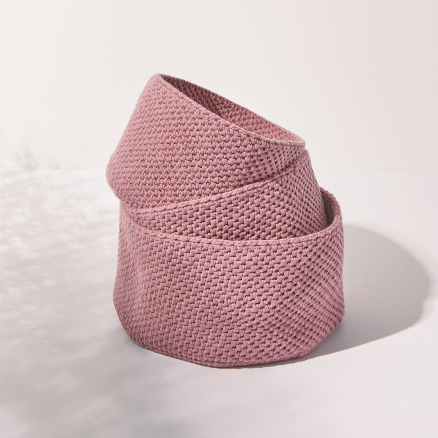 Häkelset Korb Modell 04 aus Boho Crochet: Ein rosa gehäkelter Korb in modernem Design auf weißem Hintergrund.