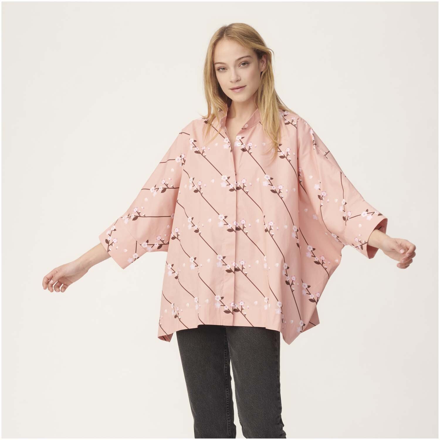 Stoffabschnitt Baumwoll-Popelin pfirsich Sakura Zweige 50x140cm: Frau trägt weite Bluse mit Sakura-Muster, gefertigt aus pfirsichfarbenem Popelin.