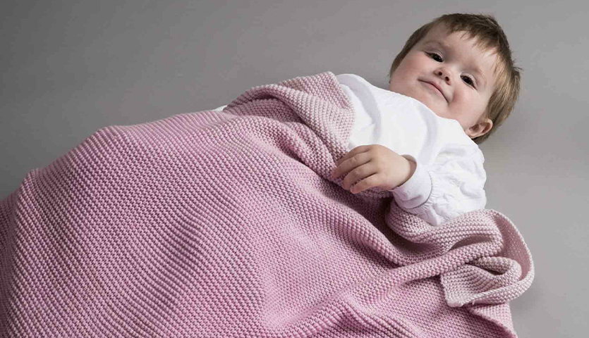 Strickanleitung für eine Babydecke aus Creative Cotton dégradé, zeigt ein weiches, pastellfarbenes Design.