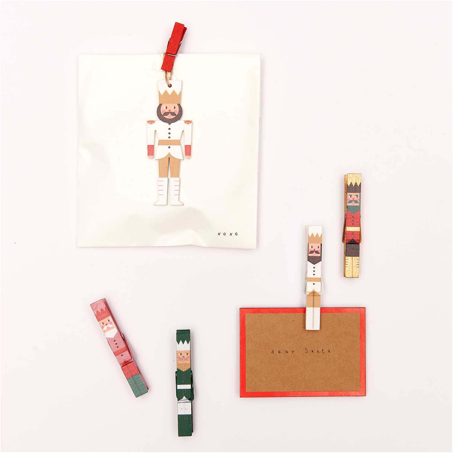Paper Poetry Tischkarten aus Kraftpapier-Rot mit Hot Foil, dekoriert mit bunten Holzklammern.