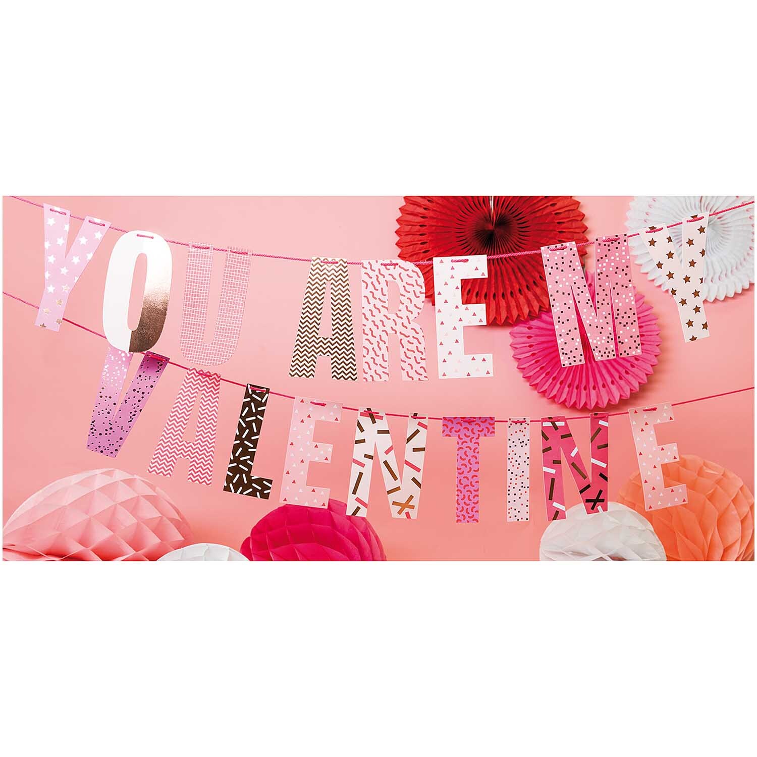 Paper Poetry Girlande "You are my valentine" in Rosa- und Rottönen, dekoriert mit Papierblumen von Rico Design.