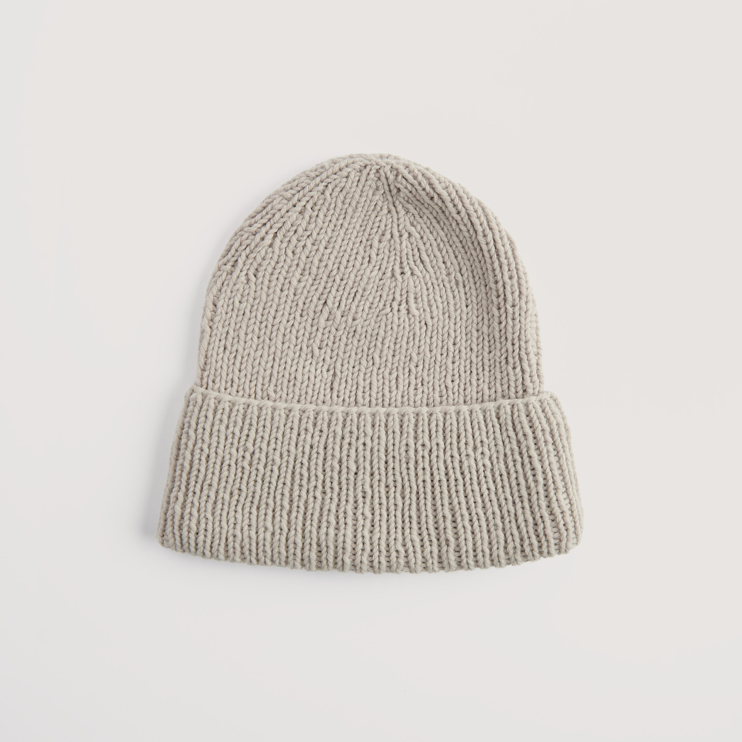 Strickset Mütze Modell 01a aus Vegan Cashmere, beige, von Rico Design, auf hellem Hintergrund.
