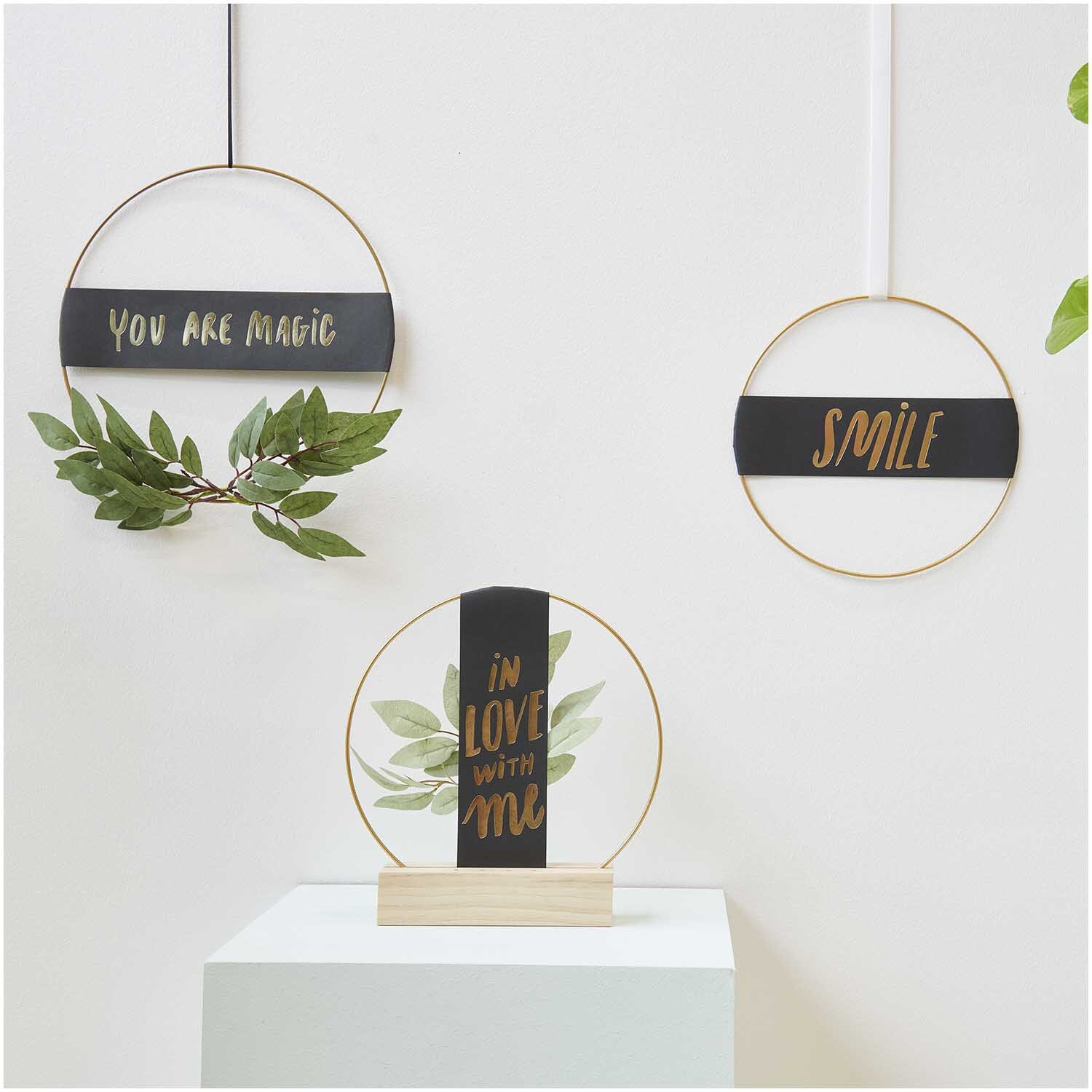 Paper Poetry Papierstreifen Smile in schwarz, dekoriert mit Pflanzen in goldenen Ringen, von Rico Design.