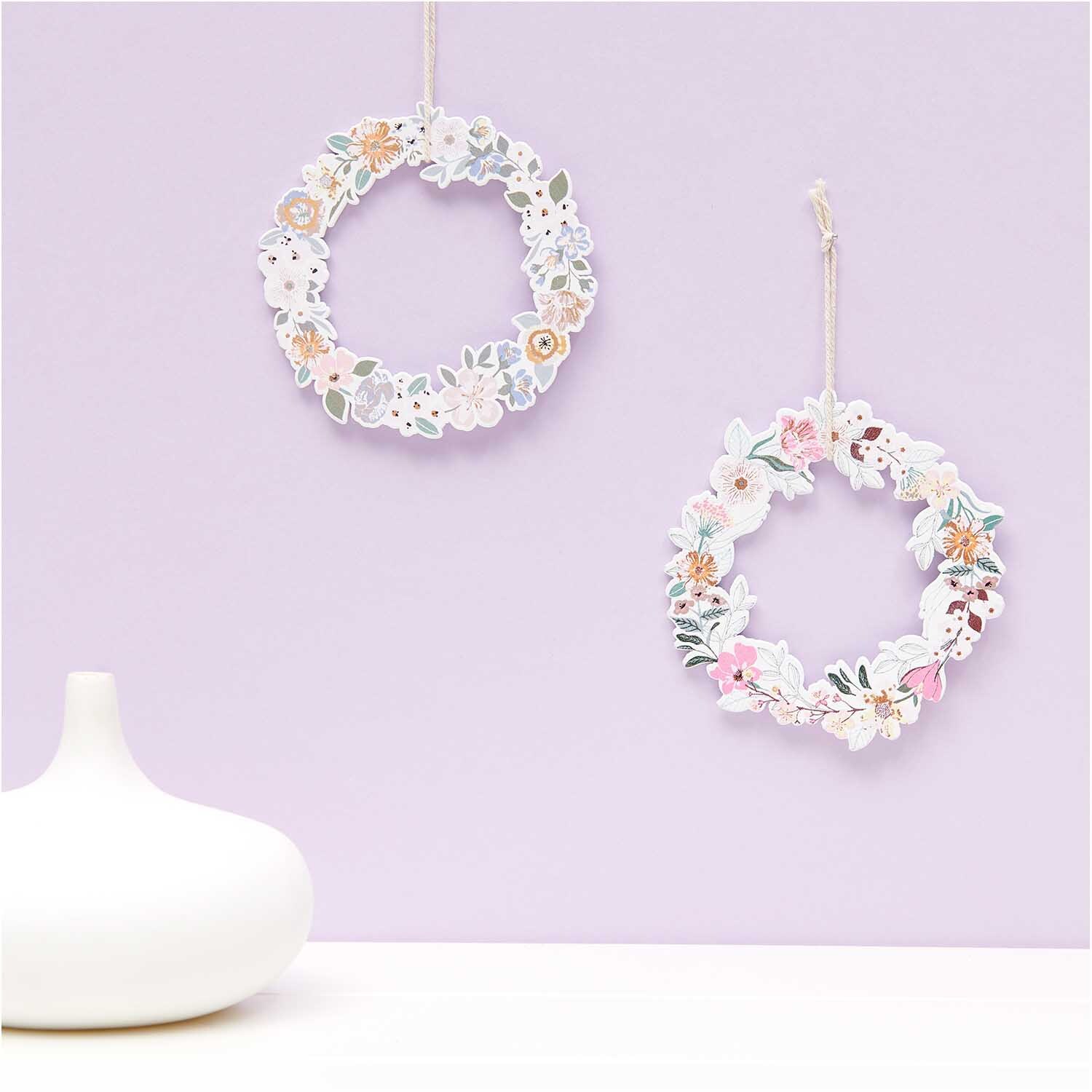 Hänger Blumenkranz bunt 1 Stück von Rico Design: Zwei dekorative Blumenkränze an einer Wand, ideal für kreative Raumgestaltung.