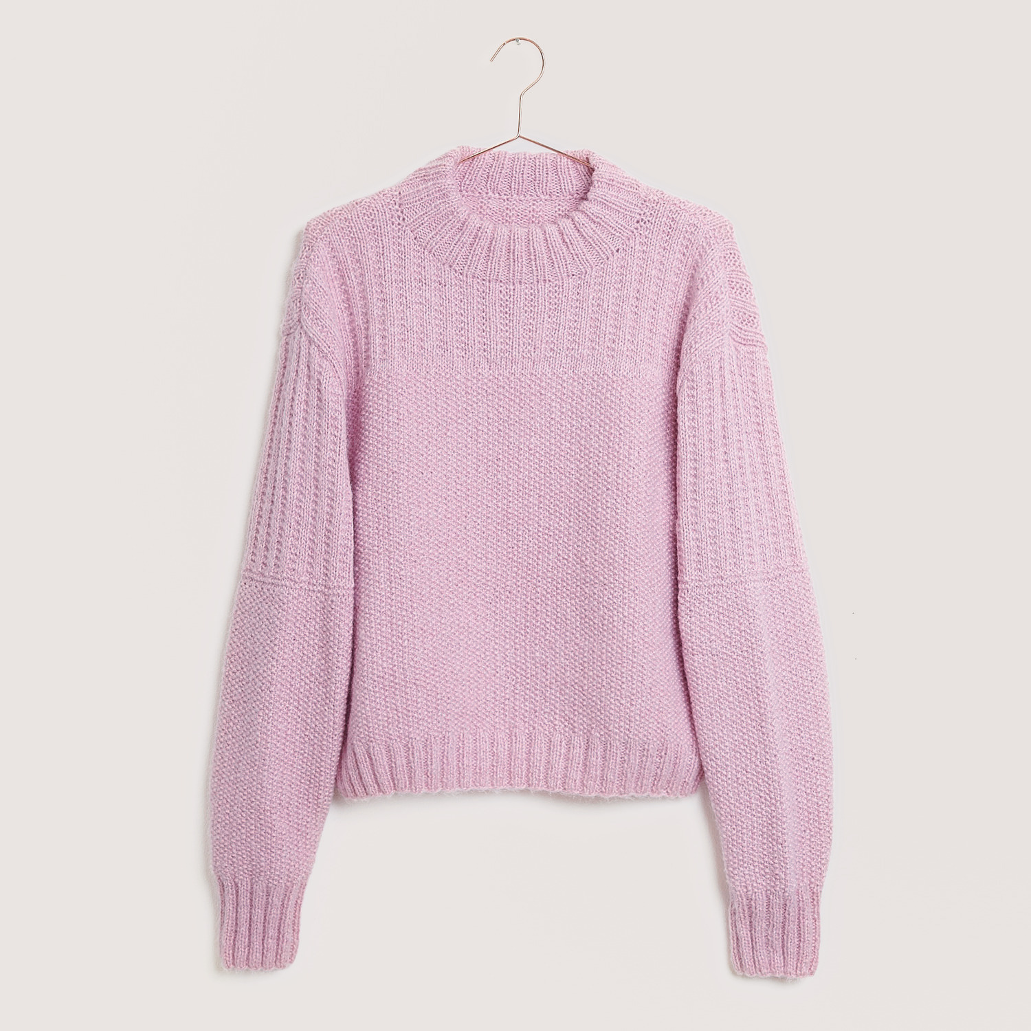 Creative Fluffily dk Pullover in zartem Rosa, gestrickt aus weicher Wolle, hängt an einem Kleiderbügel.