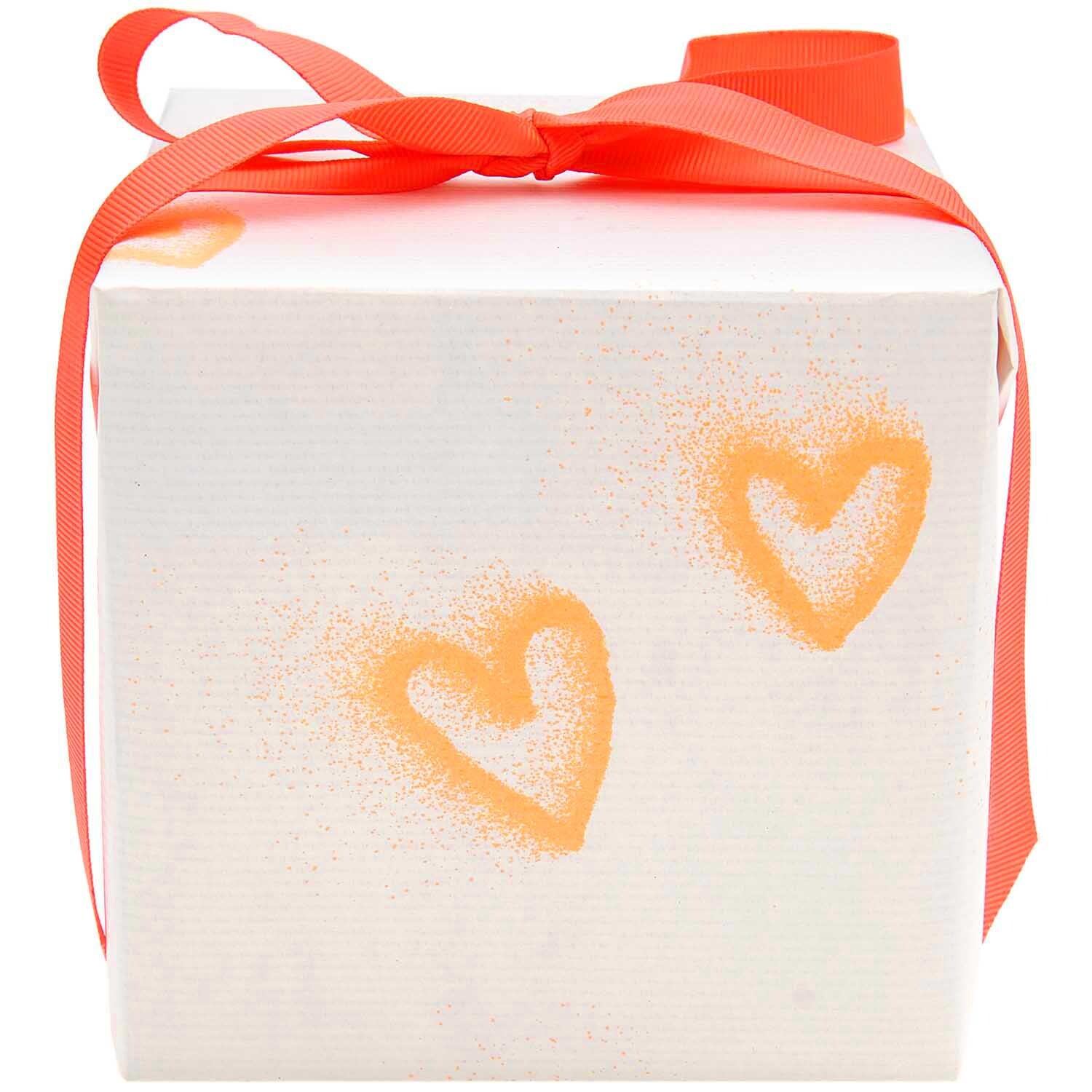 Paper Poetry Geschenkpapier mit neonorangen Herzen auf weißem Hintergrund, dekoriert mit rotem Band. Ideal für kreative Geschenkverpackungen.