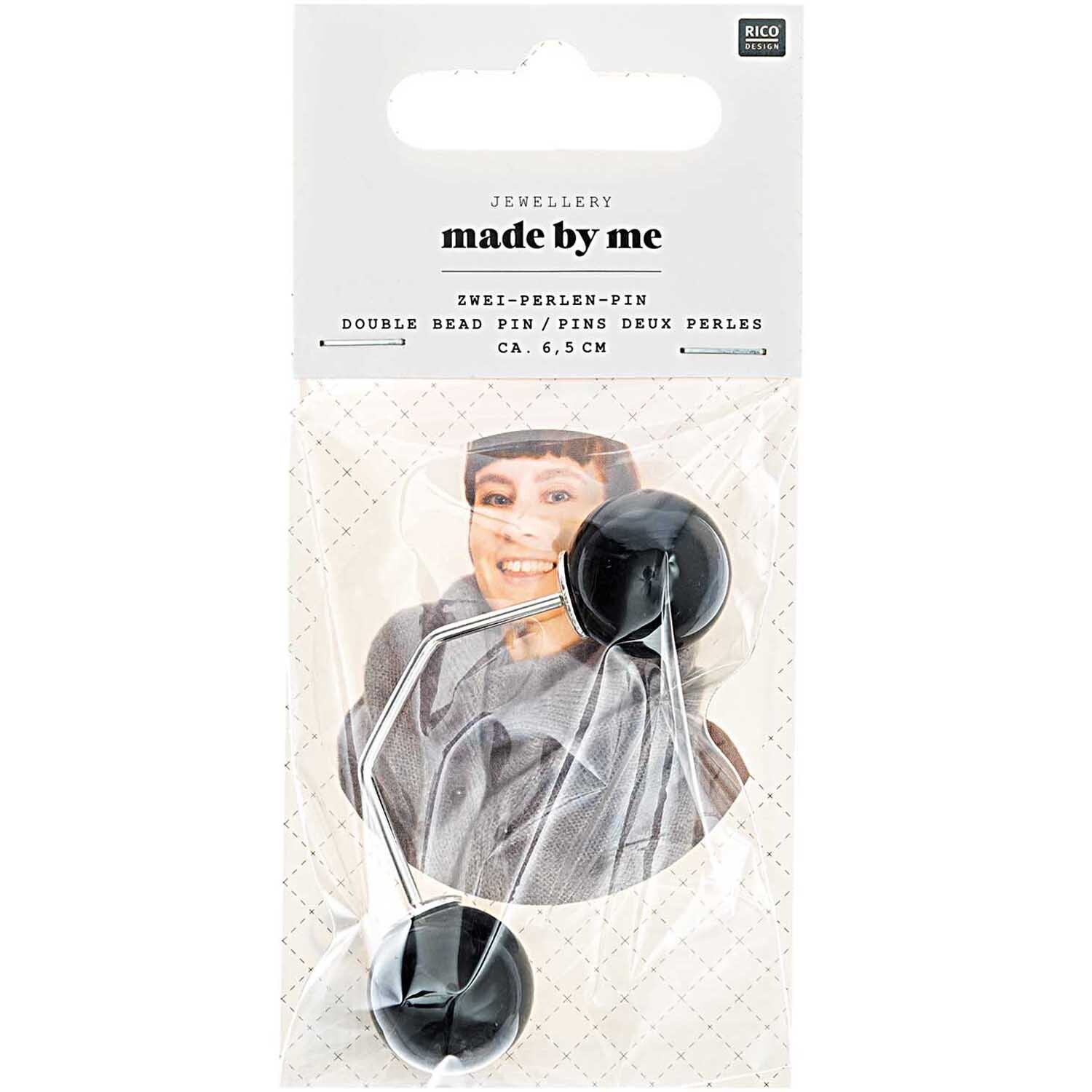 Zwei-Perlen-Pin 65mm von Rico Design in Schwarz, präsentiert in einer Verpackung mit lächelndem Model.