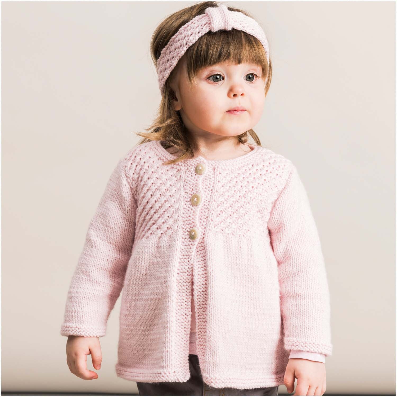 Rico Baby Dream dk uni - A Luxury Touch: Kleinkind in rosa Strickjacke mit passendem Stirnband. Ideal für sanfte, stilvolle Babybekleidung.