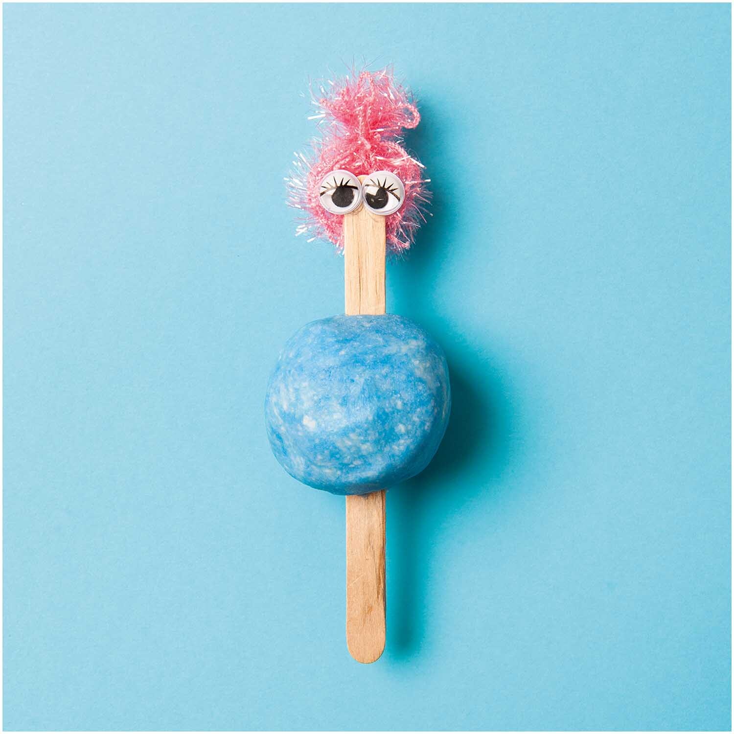Knetseife weiß-opak 300g von Rico Design, geformt als lustige Figur mit rosa Haaren auf blauem Hintergrund.