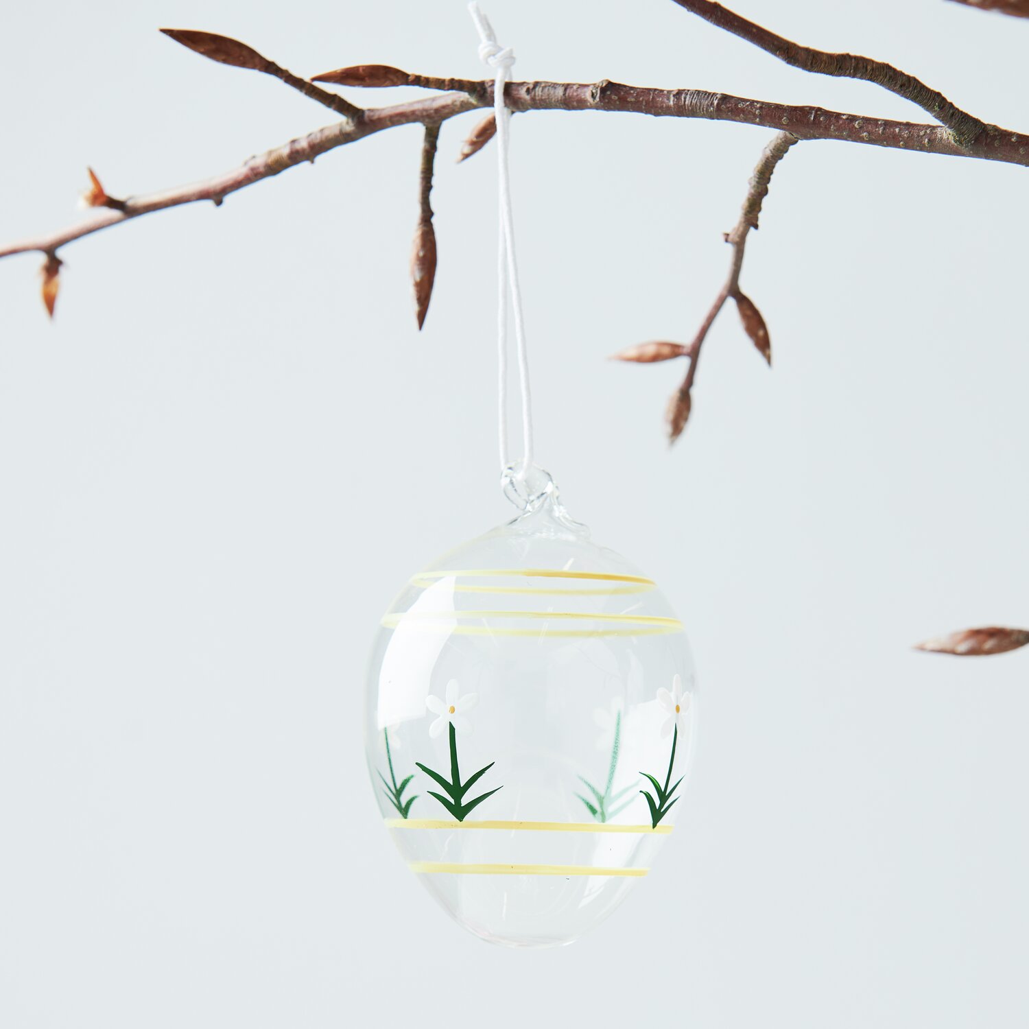 Glas Ei Blumen handbemalt von Rico Design, hängend an einem Ast, mit zarten Blumenmotiven.
