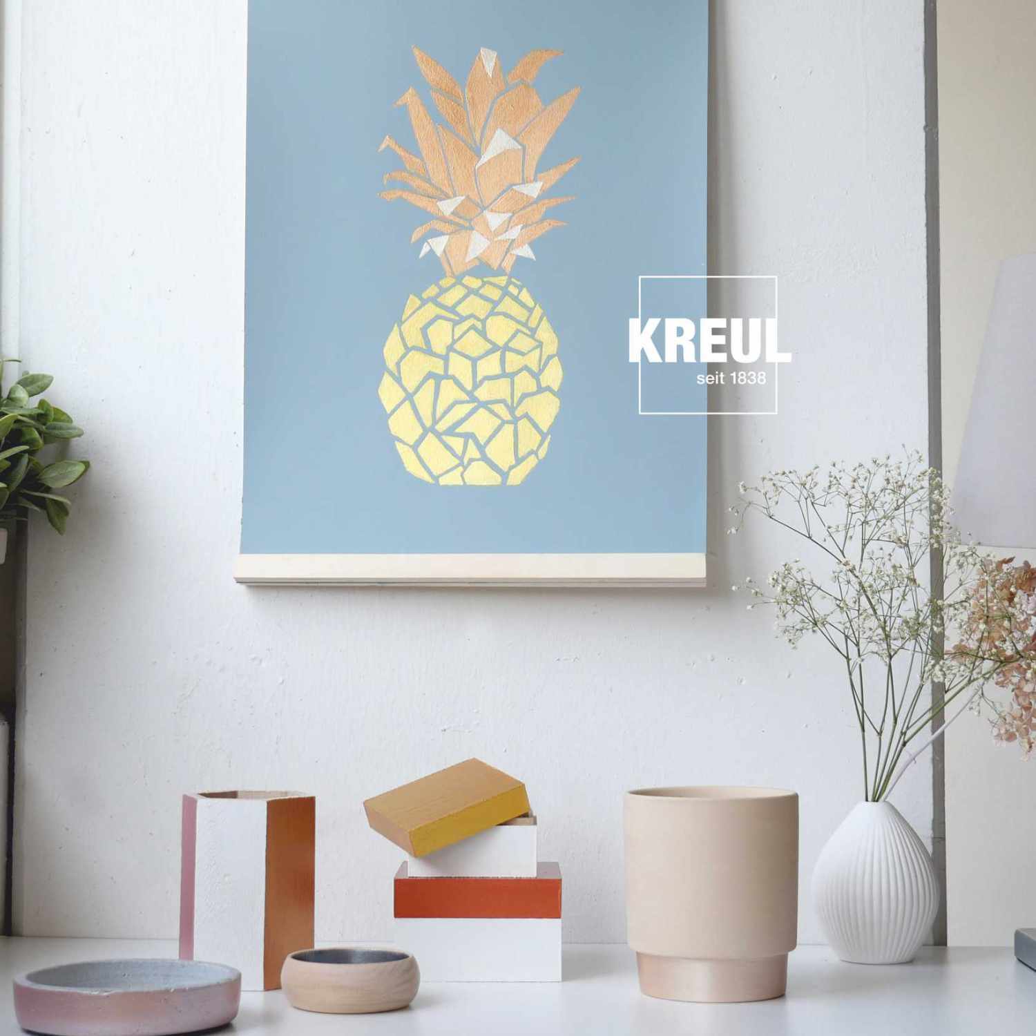 Acryl Metallicfarben Set Glamour Living 20ml 6 Stück: Kunstwerk mit goldener Ananas auf blauem Hintergrund, dekoriert mit KREUL-Produkten.