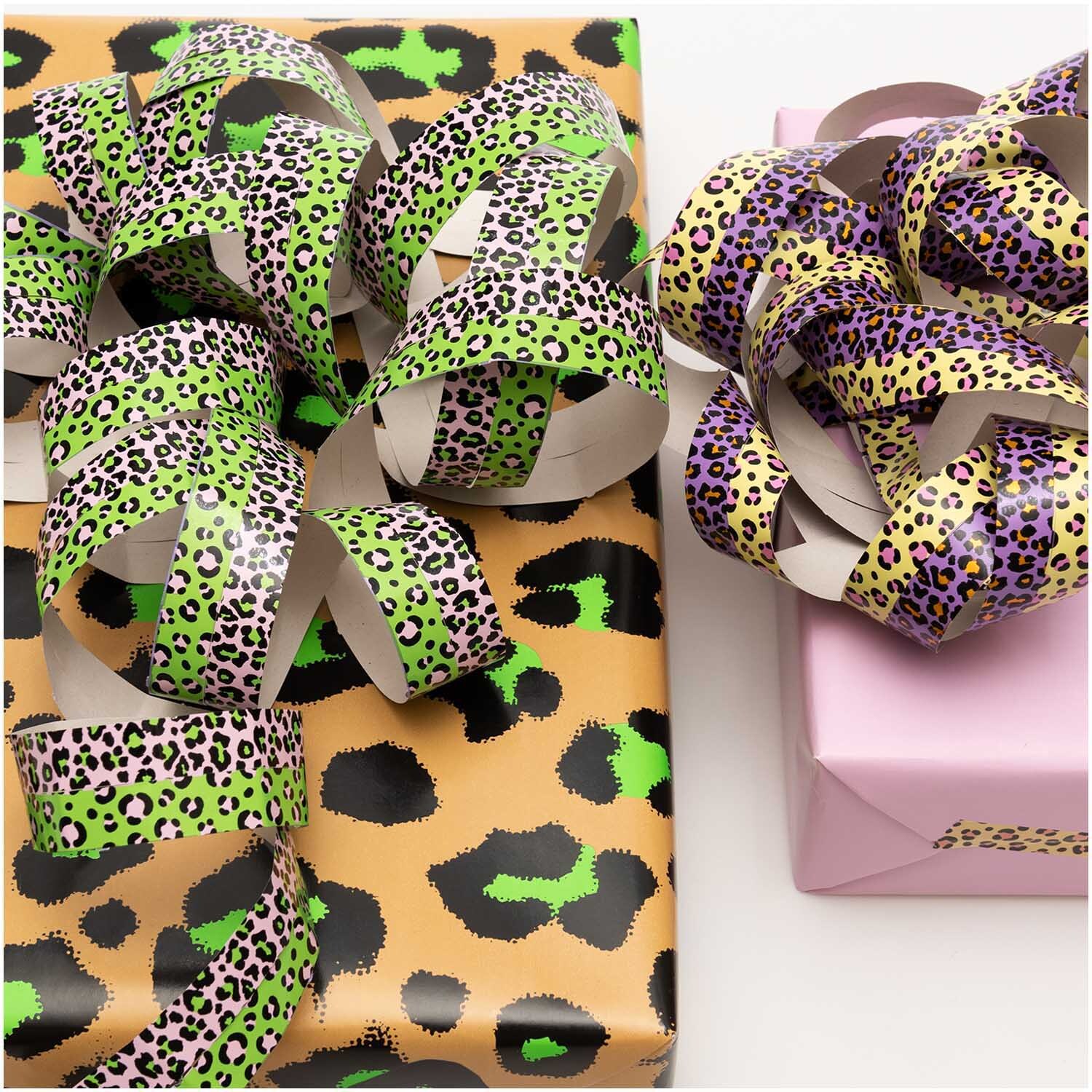 Luftschlangen Acid Leo gold 3,8m von Rico Design auf Geschenken mit Leopardenmuster in Grün und Lila.