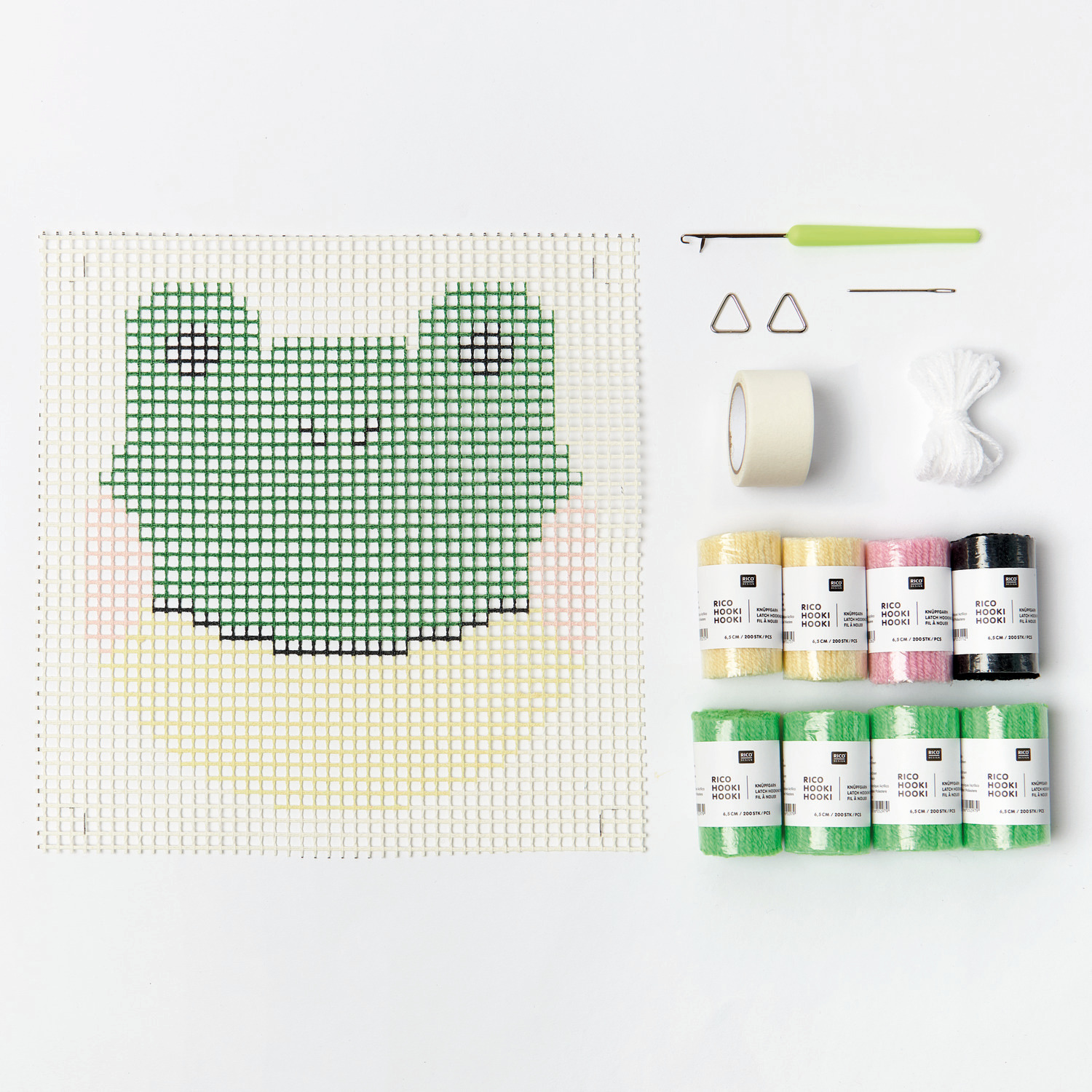 Rico Hooki Hooki Knüpfset Wandbehang Frosch zeigt ein Set mit grünem Froschmotiv, Garnen und Werkzeugen auf weißem Hintergrund. Ideal für DIY-Projekte.