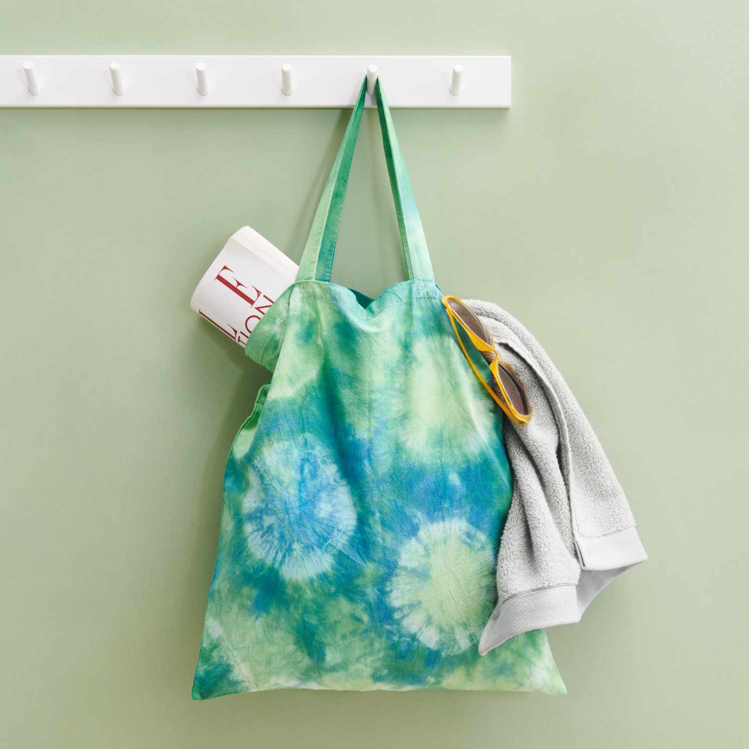 Javana Batik-Textilfarbe: Bunte Stofftasche in Grün und Blau, gefüllt mit Zeitschrift und Handtuch.