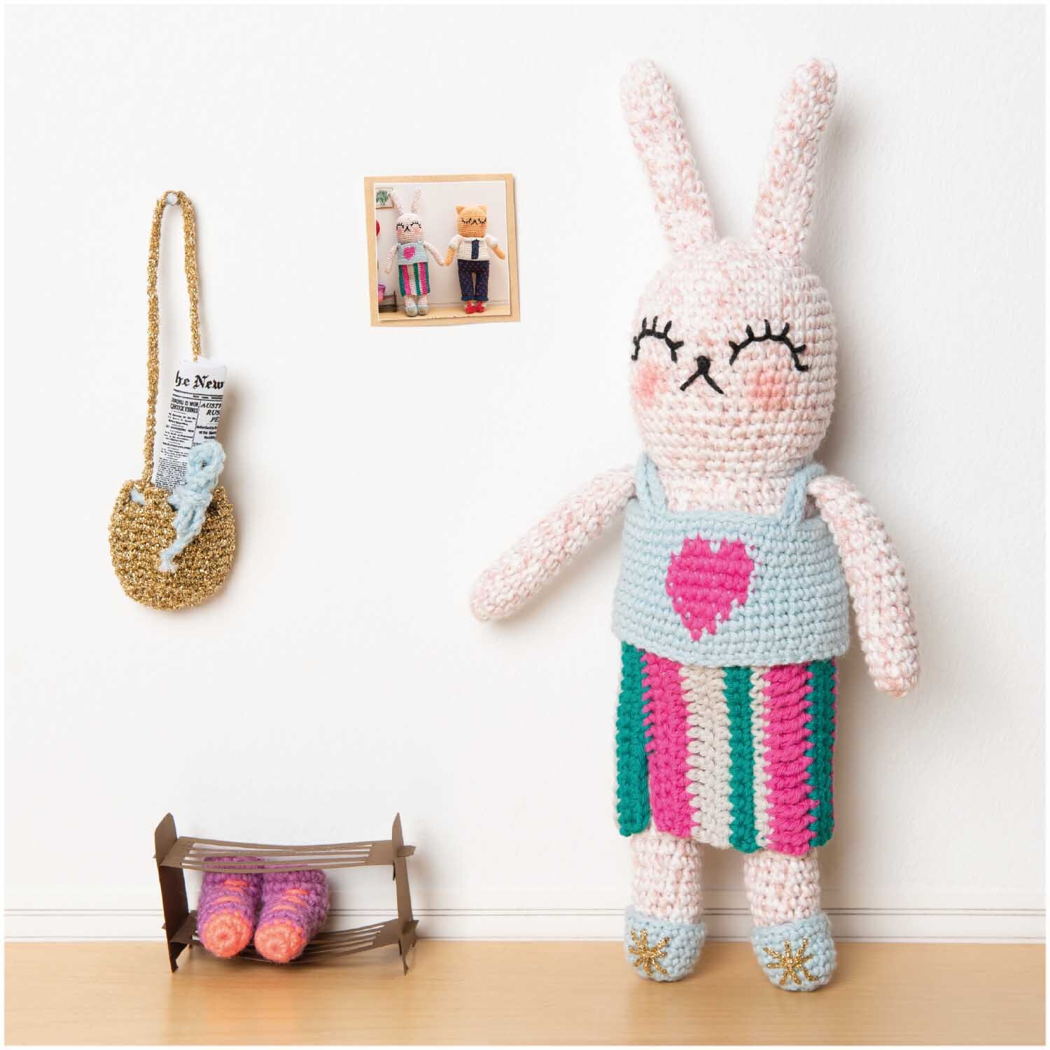 Creative Ricorumi dk: Gehäkelter Hase in buntem Kleid mit Herzmotiv, dekoriert mit Rico Design Garn.