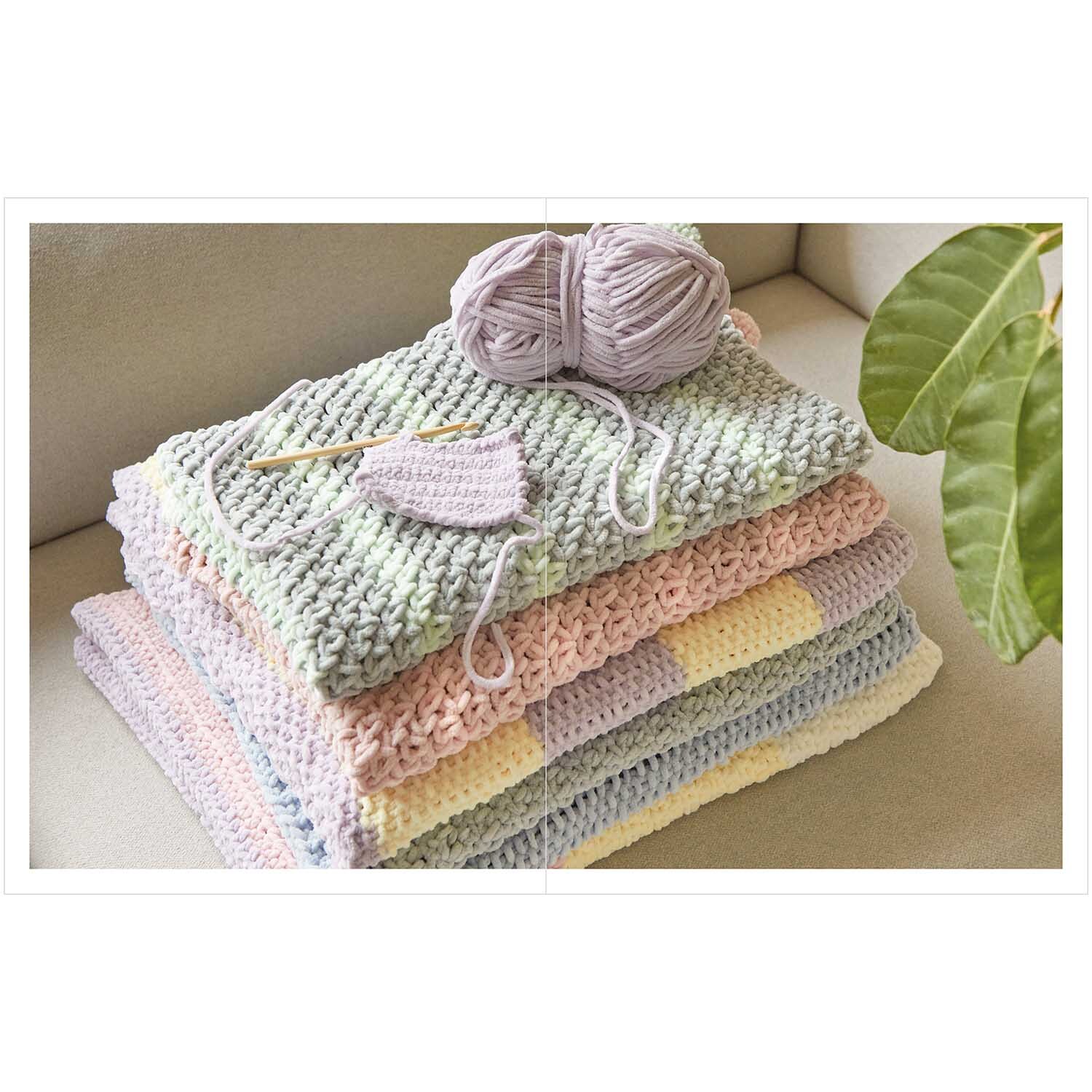 Baby Chenillove: Weiche, pastellfarbene Strickdecken und Garn von Rico Design auf einem Sofa.