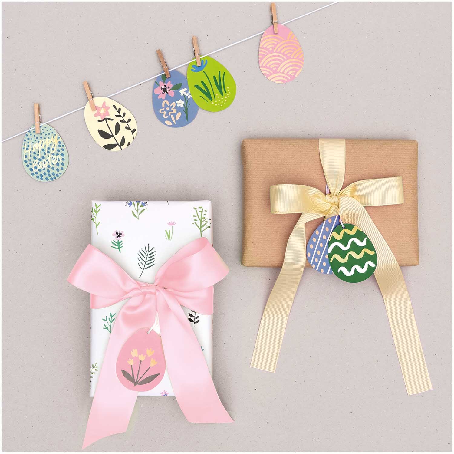 Paper Poetry Papieranhänger Bunny Hop Ostereier mit Blumenmotiven, dekorativ an Geschenken befestigt. Ideal für kreative Geschenkverpackungen.