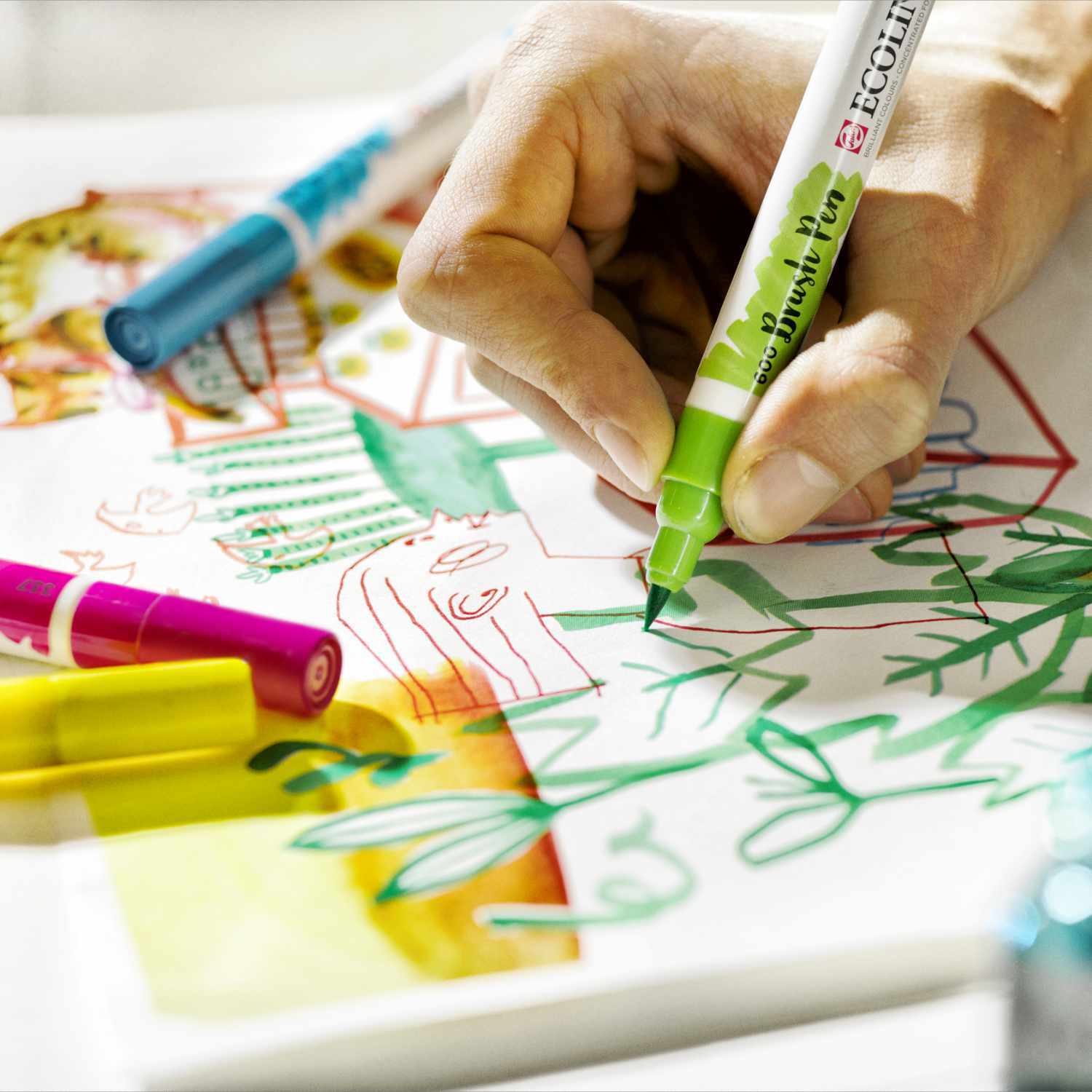 Brush Pen Set 10 Stück: Eine Hand zeichnet mit einem grünen Stift von ECOLINE auf Papier.
