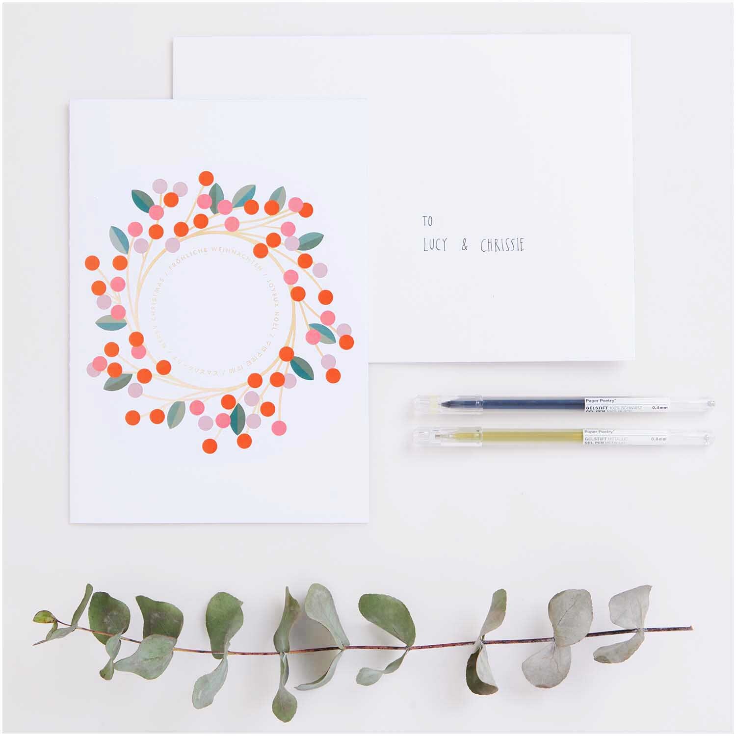 Paper Poetry Kartenset Kranz A5 mit buntem Kranzmotiv, zwei Stiften und einem Eukalyptuszweig.
