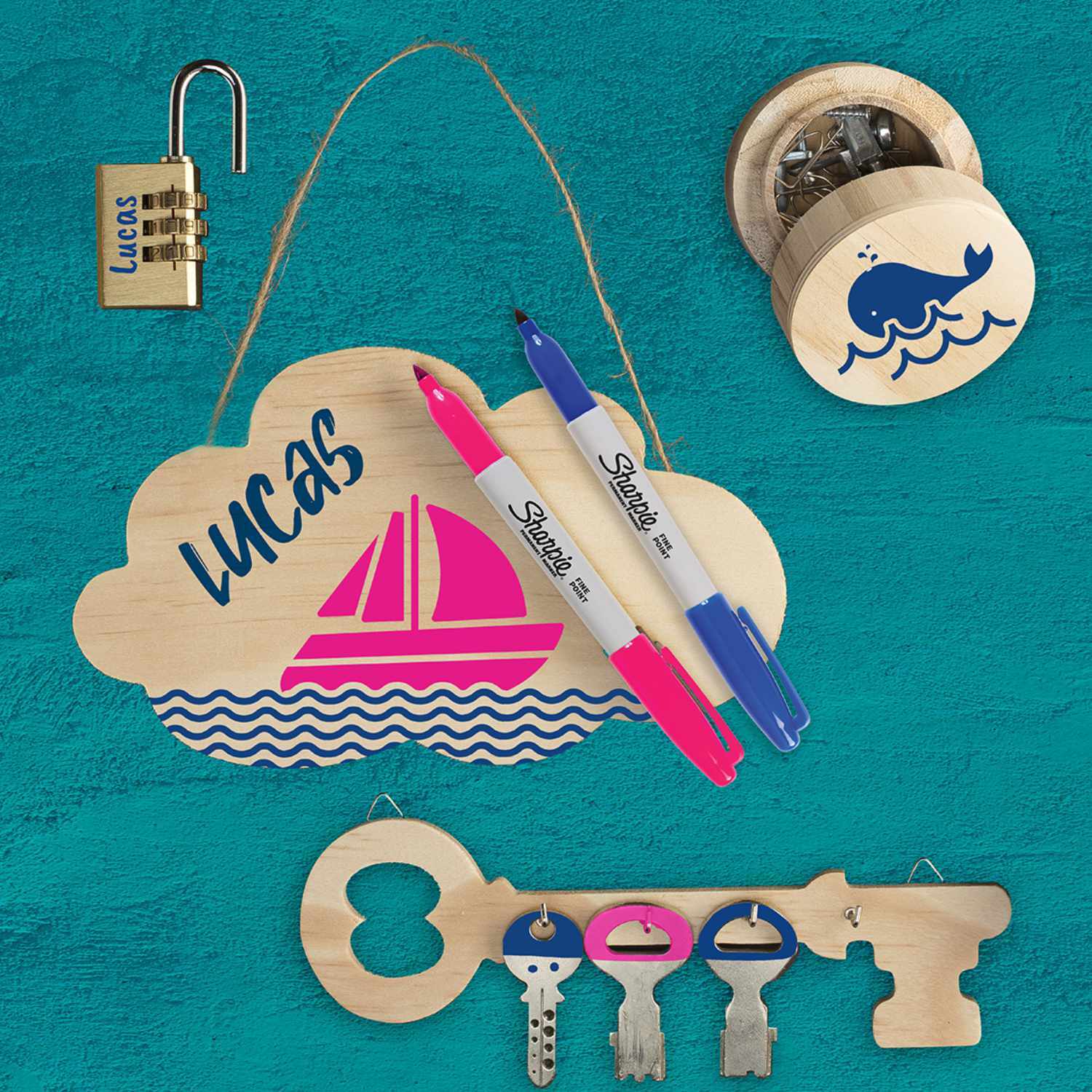 Permanentmarker 0,9mm von Sharpie in Blau und Pink auf einem dekorativen Holzschild mit Segelbootmotiv.