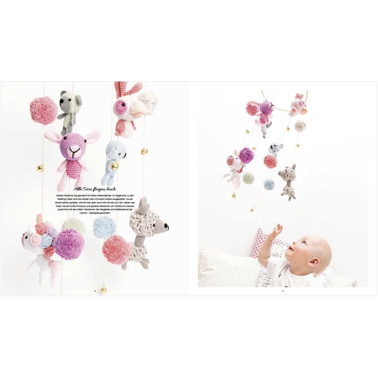 Ricorumi Baby Little Animals: Ein Baby spielt mit einer bunten Mobile aus gehäkelten Tieren von Rico Design.