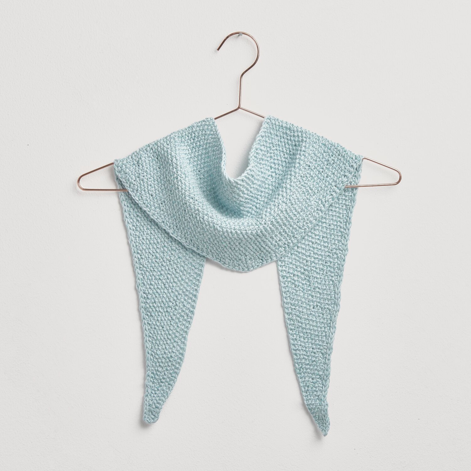 Strickset Mini-Dreieckstuch Modell 09 in Hellblau, aus hochwertiger Baumwoll-Seiden-Kaschmir-Mischung, präsentiert auf einem Kleiderbügel.