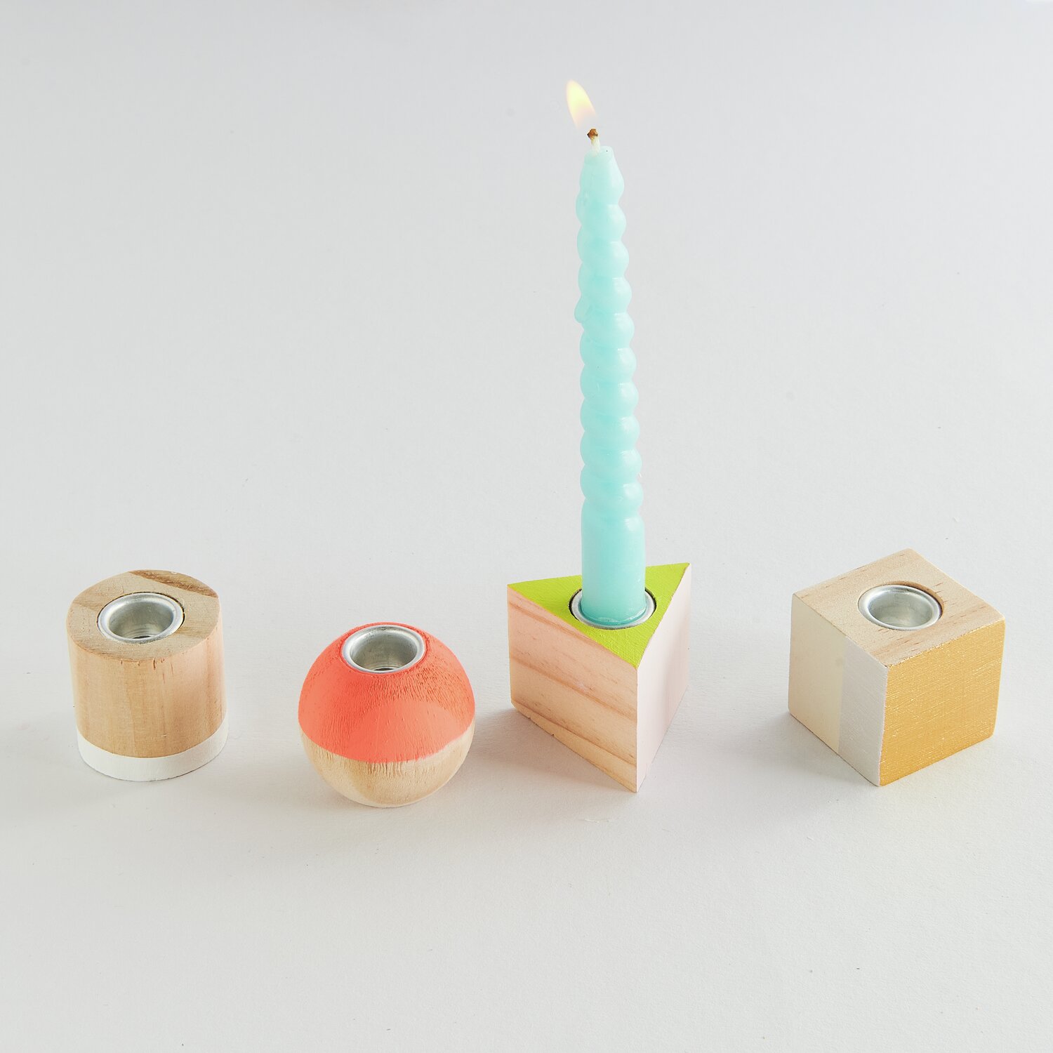 Mini Kerzenhalter Geometrische Formen, 3x3x3cm, 4 Stück, in Holzoptik mit bunten Akzenten.