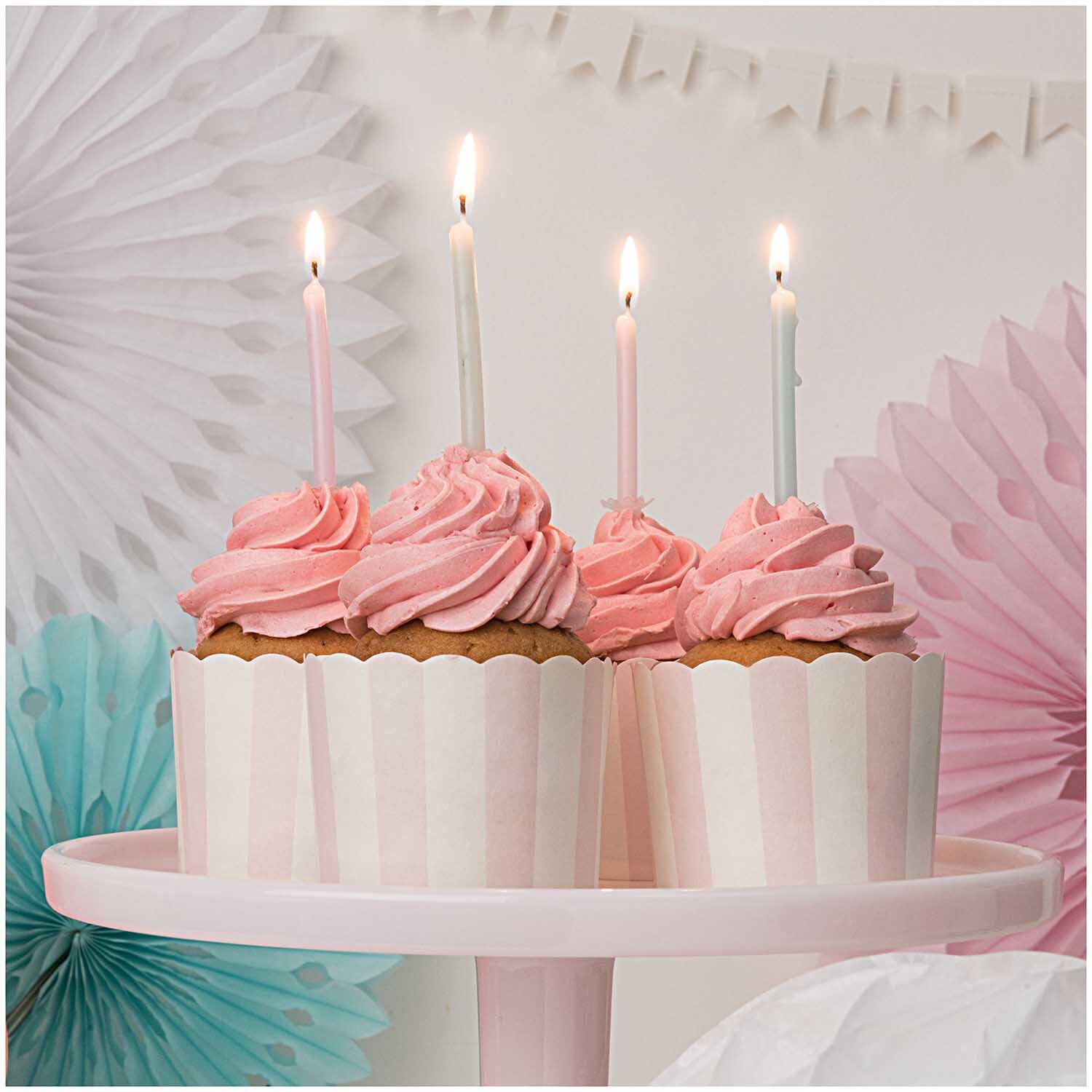 Wabenpapier Blumen aqua 3 Stück von Rico Design, dekoriert mit pastellfarbenen Cupcakes und Kerzen.