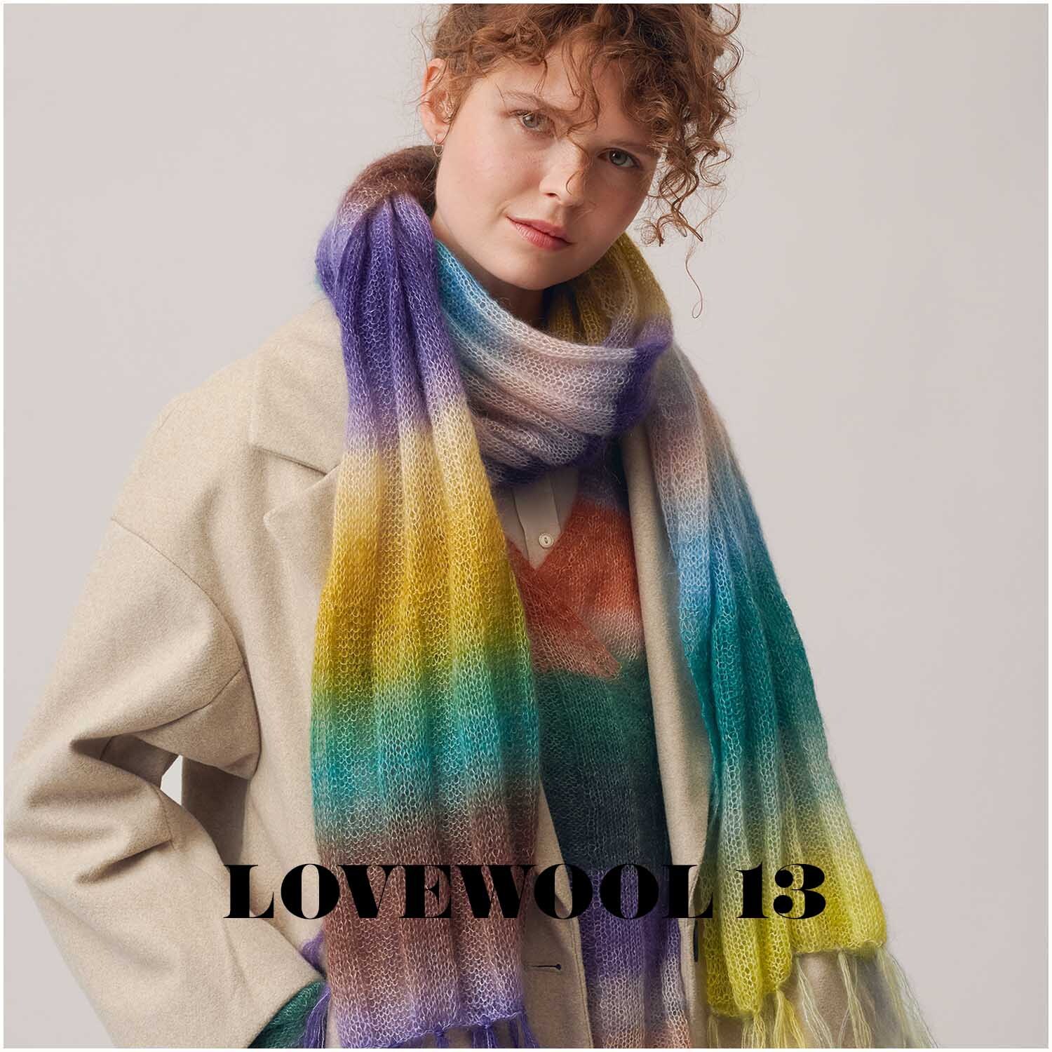 Essentials Super Kid Mohair Loves Silk Print: Frau trägt bunten Schal von Rico Design, perfekt für den Frühling.