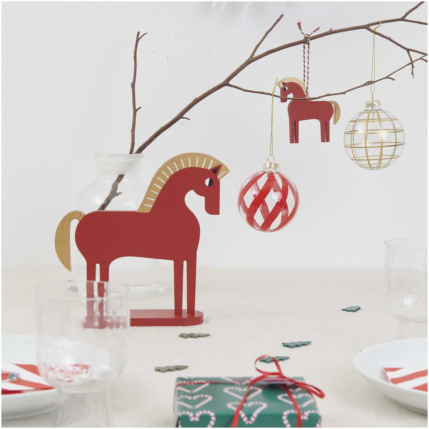 Deko-Figur Holz-Pferd rot 20x5x19,6cm von Rico Design auf einem Tisch mit Weihnachtsdekoration.