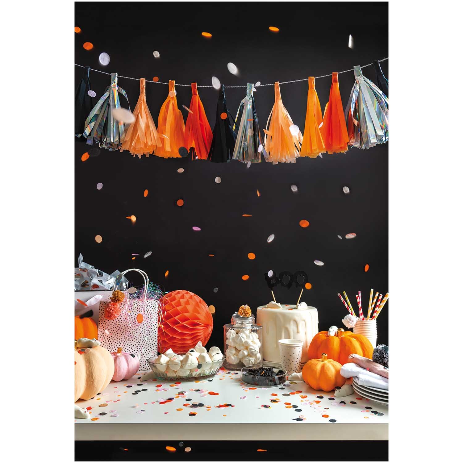 Quasten-Girlande 2m 12 Quasten von Rico Design in Orange-Schwarz hängt über einem dekorierten Tisch mit Kürbissen und Partyzubehör.