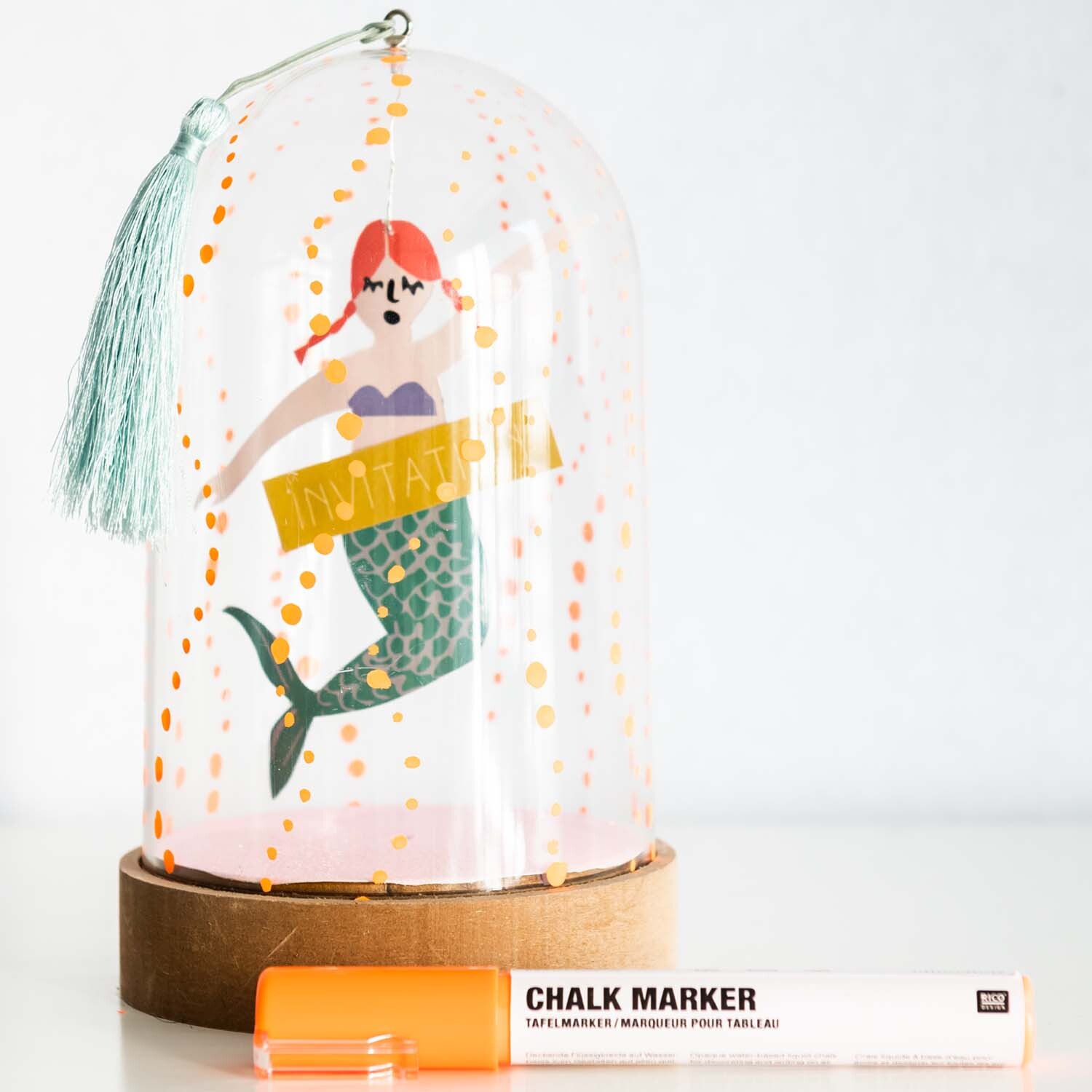 Bastelanleitung Meerjungfrau im Glas: Eine dekorative Glaskuppel mit Meerjungfrau-Design und orangefarbenem Kreidestift.
