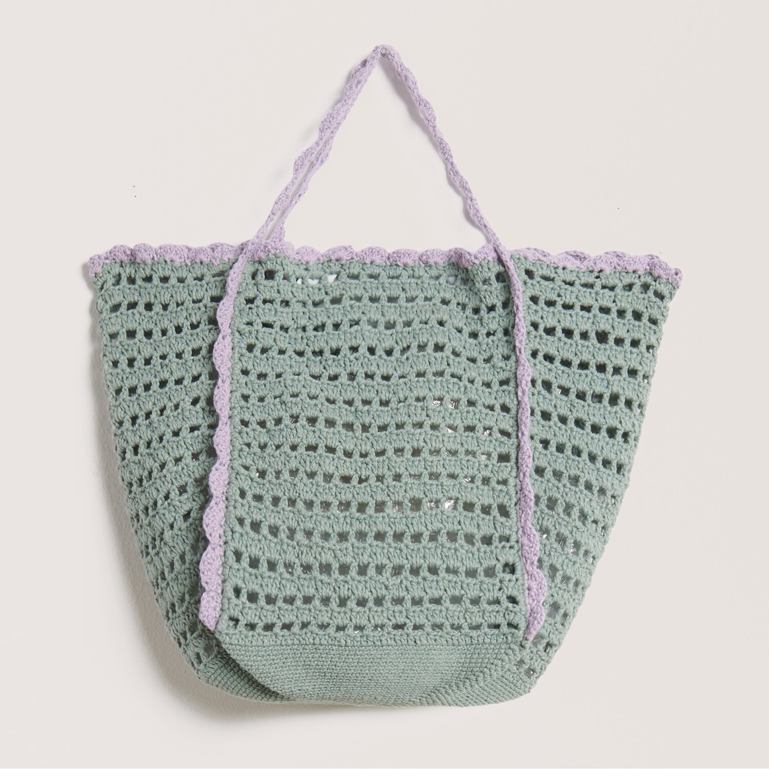 Häkelset Tasche Modell 29 zeigt eine handgefertigte Tasche in Salbei mit fliederfarbenen Akzenten. Ideal für kreative Projekte.