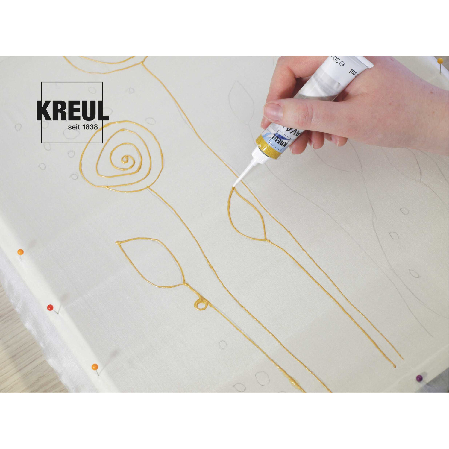 Javana Malen auf Seide Starterset: Hand zeichnet mit goldener Farbe auf weißem Stoff. Marke: KREUL.
