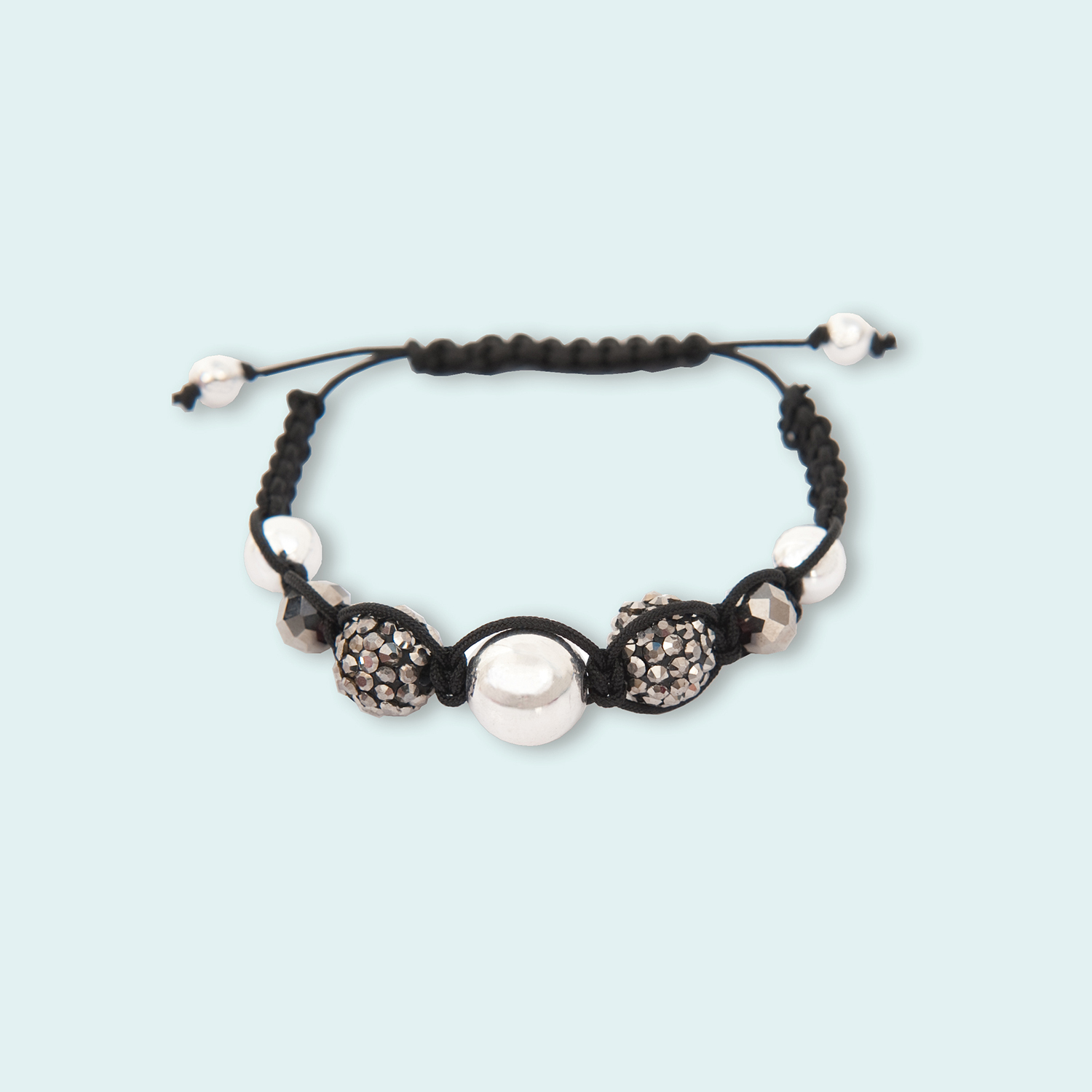 Anleitung Makramee Glasschliffset Armband mit schwarzen und weißen Perlen auf hellblauem Hintergrund.
