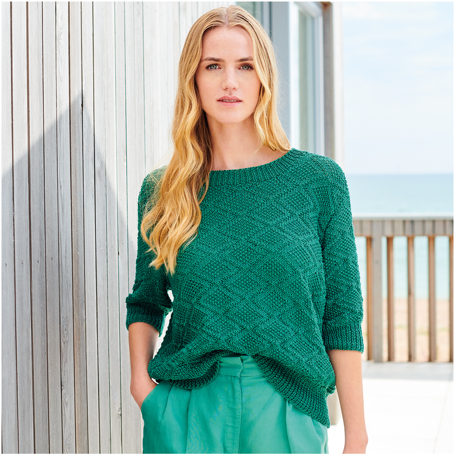 Strickset Shirt Modell 25 aus Lovewool Nr. 18, smaragdgrün, getragen von Frau am Strand.