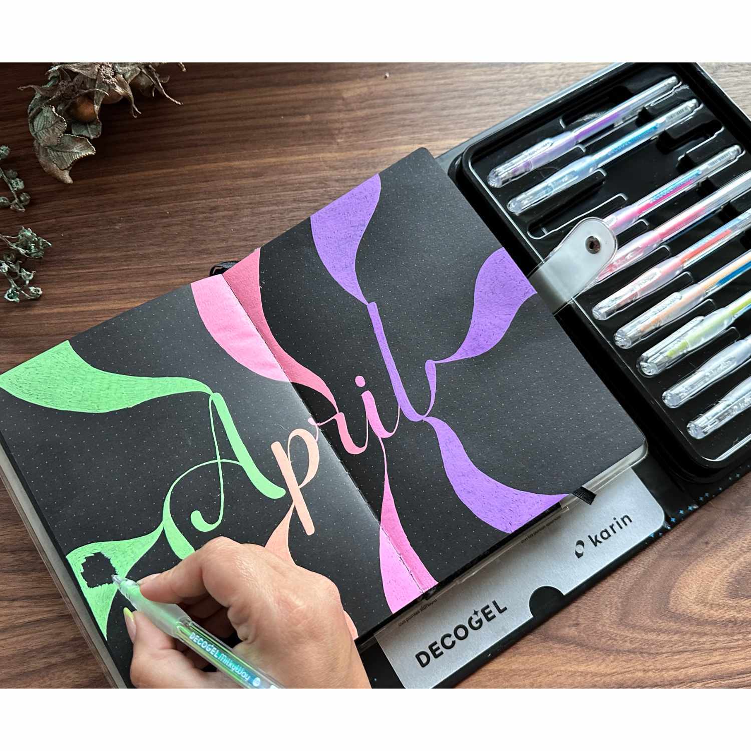 Decogel-Set Milky Way 10 Stück: Hand schreibt mit bunten Stiften von Karin in einem Notizbuch.