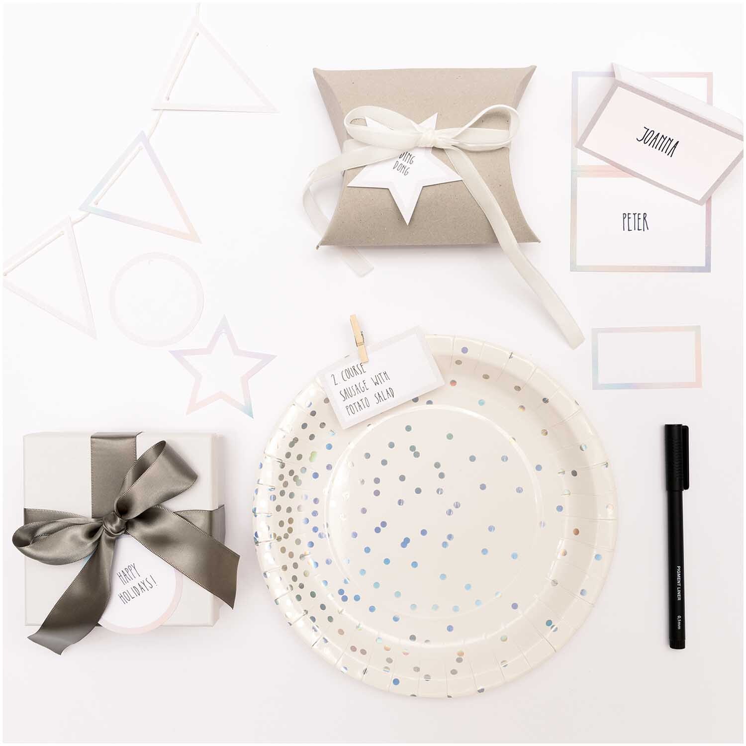 Paper Poetry Papierwimpel in irisierendem Glitzerdesign, dekoriert mit Geschenken und Partyzubehör.